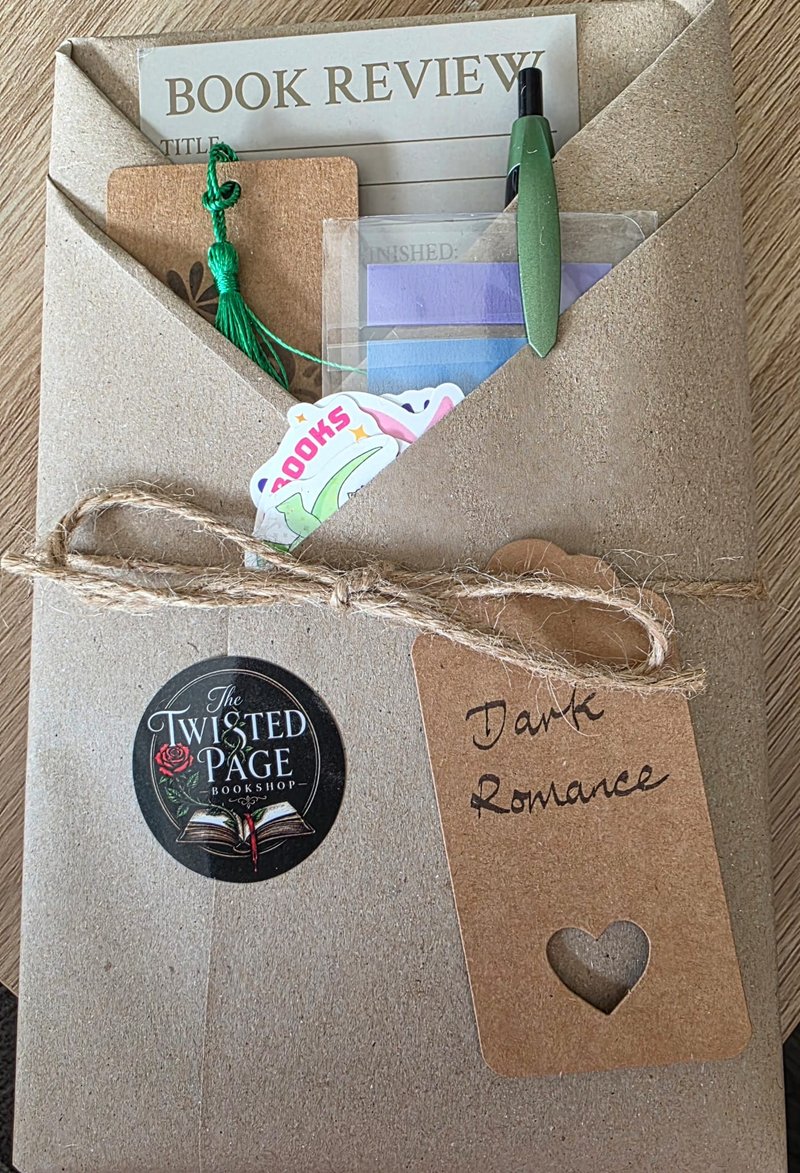 Blind Date with a Book, Dark Romance pick — a kraft-paper wrapped parcel tied with twine, with a heart-cutout "Dark Romance" gift tag